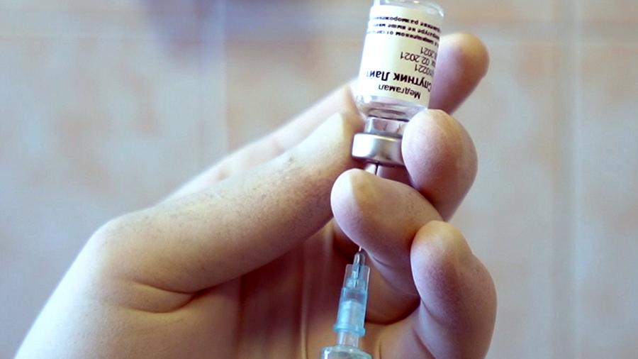Медицинский работник держит контейнер с вакциной «Спутник Лайт»